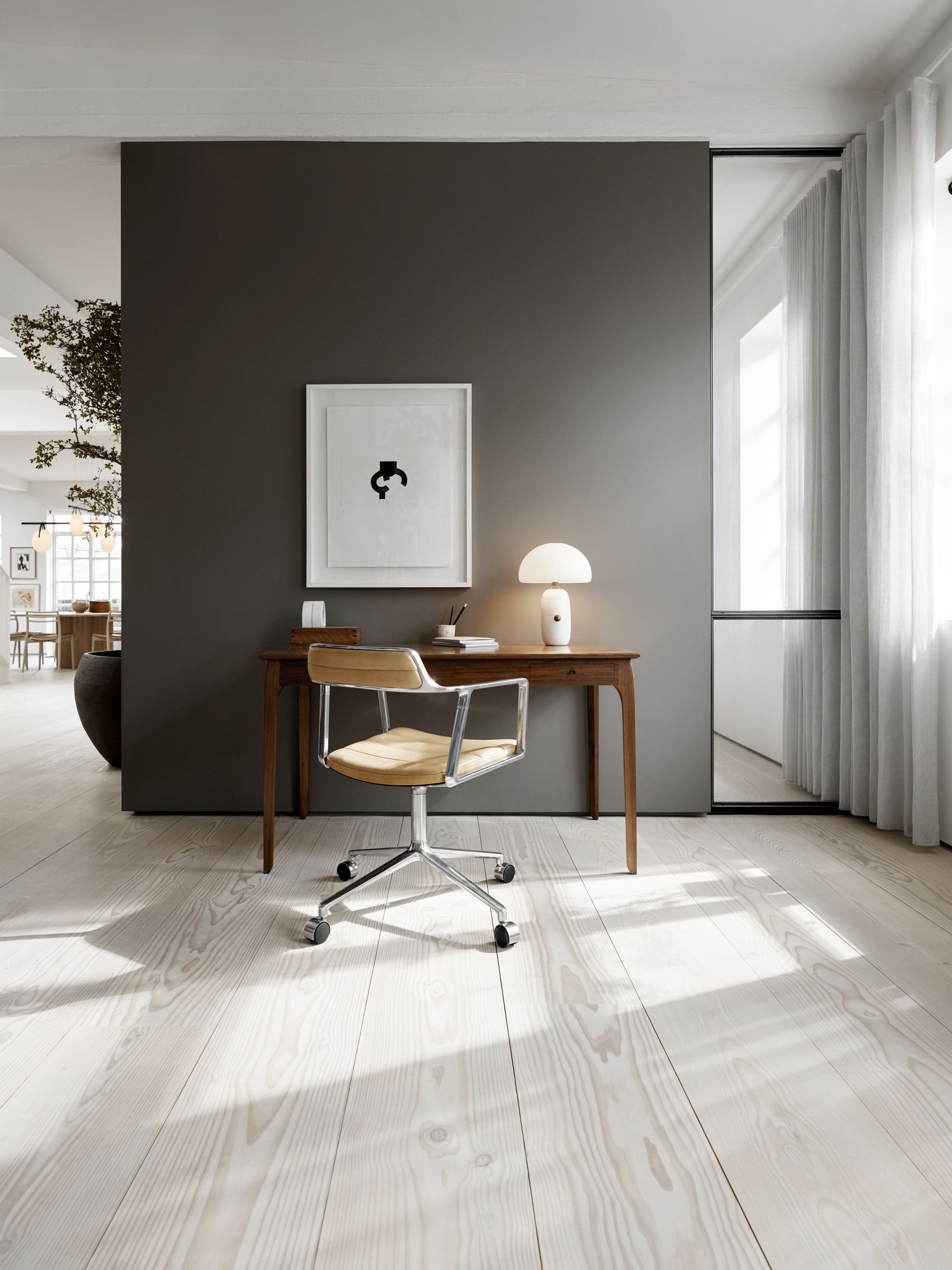 VIPP452 Swivel Stuhl mit hellem Lederbezug und Gleitern vor einem Schreibtisch in einem modernen Arbeitszimmer.
