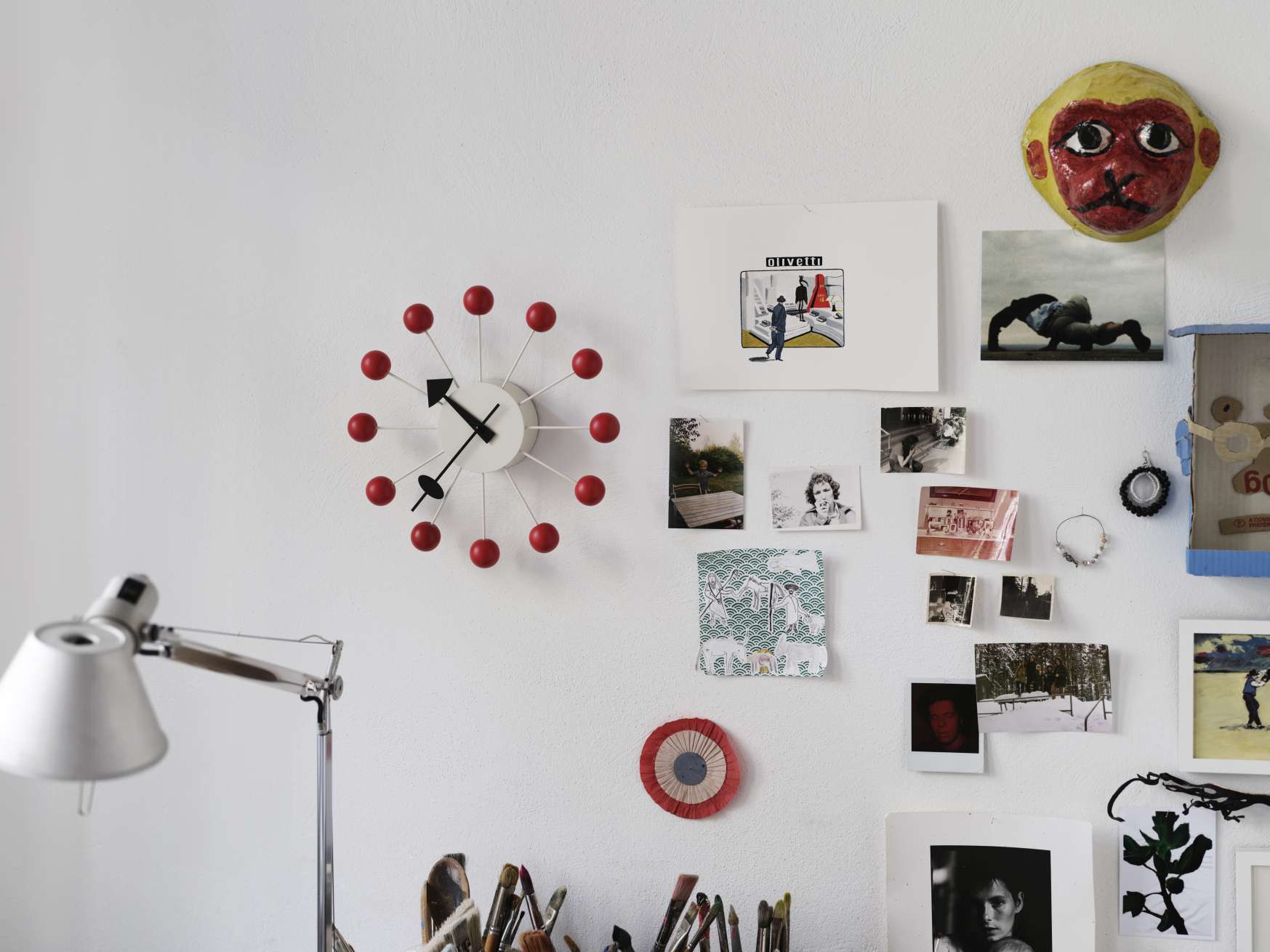 Nahaufnahme der Vitra Ball Clock Wanduhr in Rot, modernes Designelement an weißer Wand.