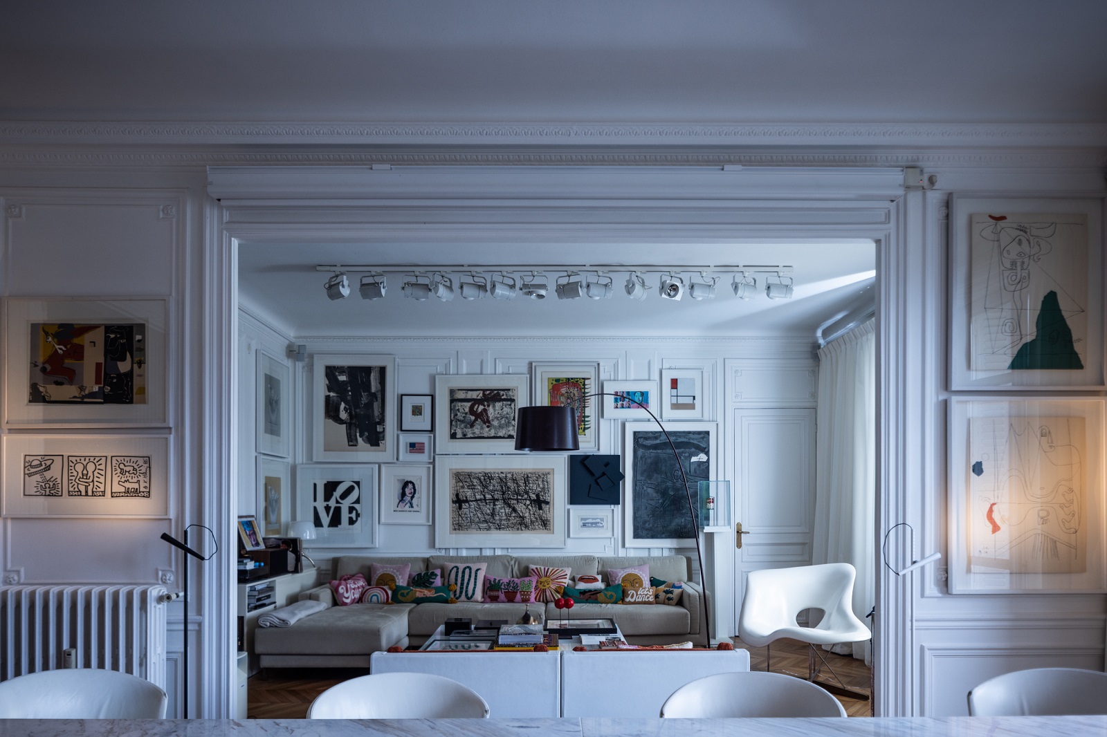 Twiggy Bogenleuchte von Foscarini in stilvollem Wohnzimmer mit Kunstwerken und Designermöbeln.
