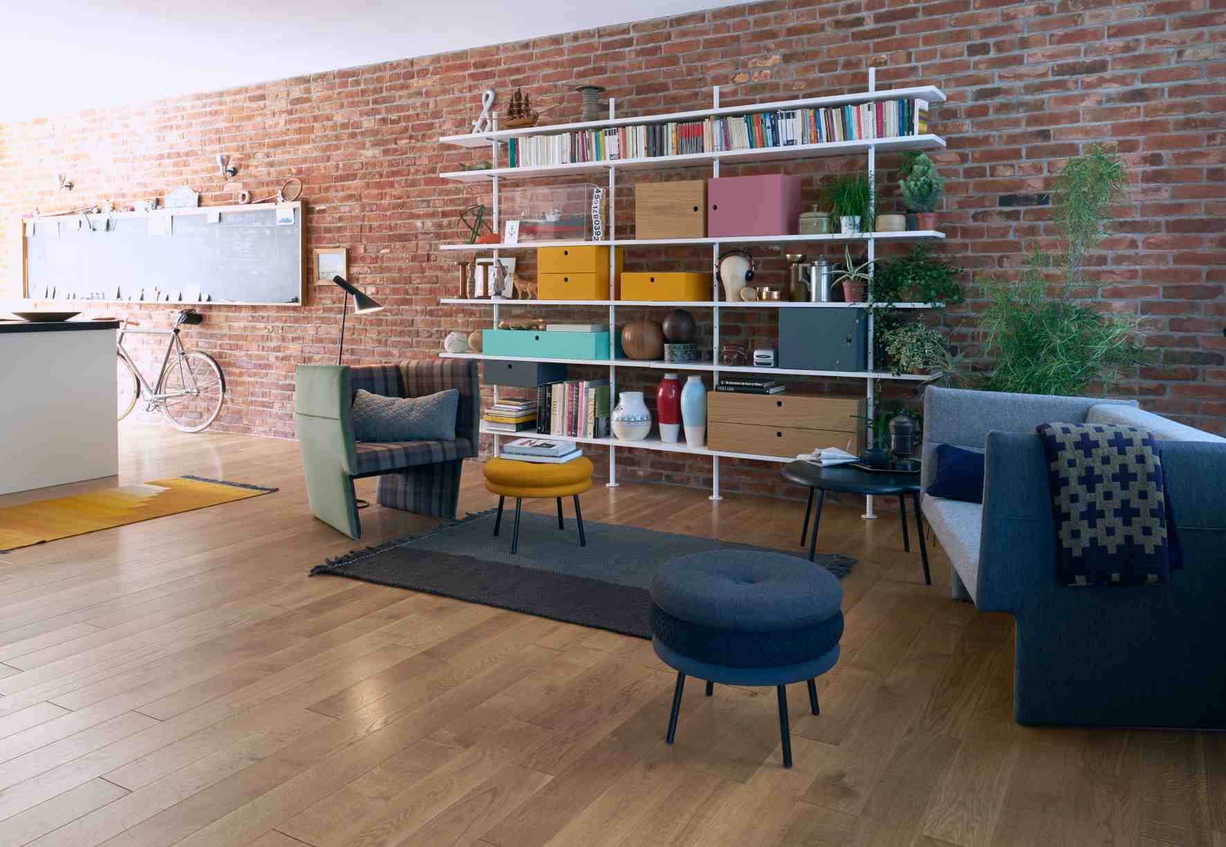 Wohnzimmer mit Richard Lampert Eiermann Regal, 160cm breit, Eiche massiv, Basaltgrau, gefüllt mit Büchern und Deko.