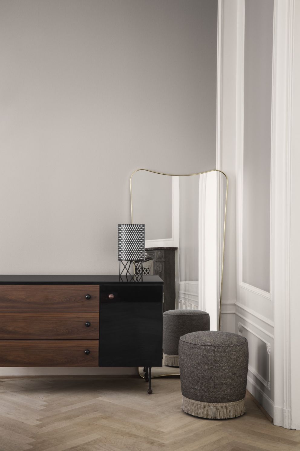 Elegantes Gubi Sideboard 62 mit Holzschubladen und schwarzer Tür, Lampe und Spiegel im Interieur.