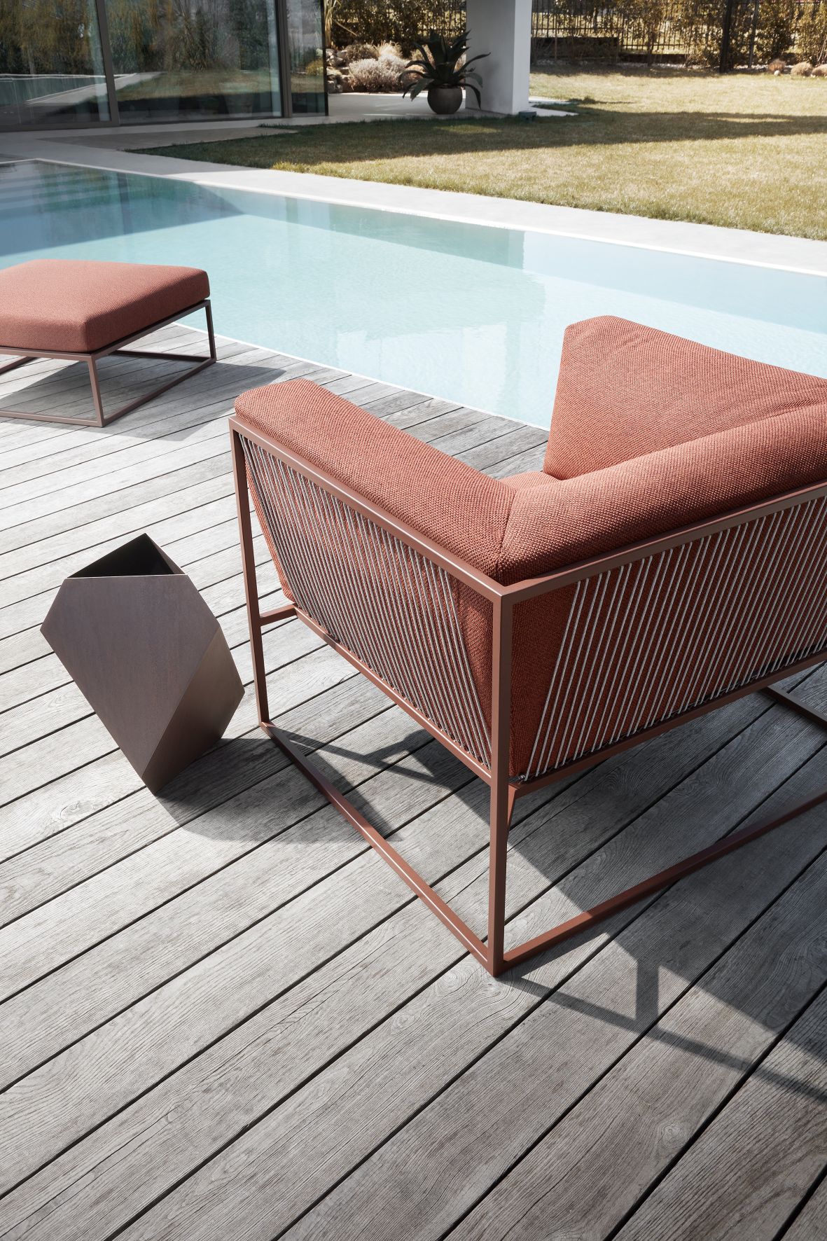 Arpa Outdoor Sofa von MDF Italia in Terrakotta mit passendem Hocker am Pool.