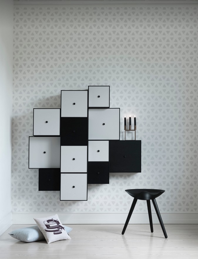 Schwarzer ML42 Hocker von Audo vor einer Wand mit modularen Schränken und Kissen.