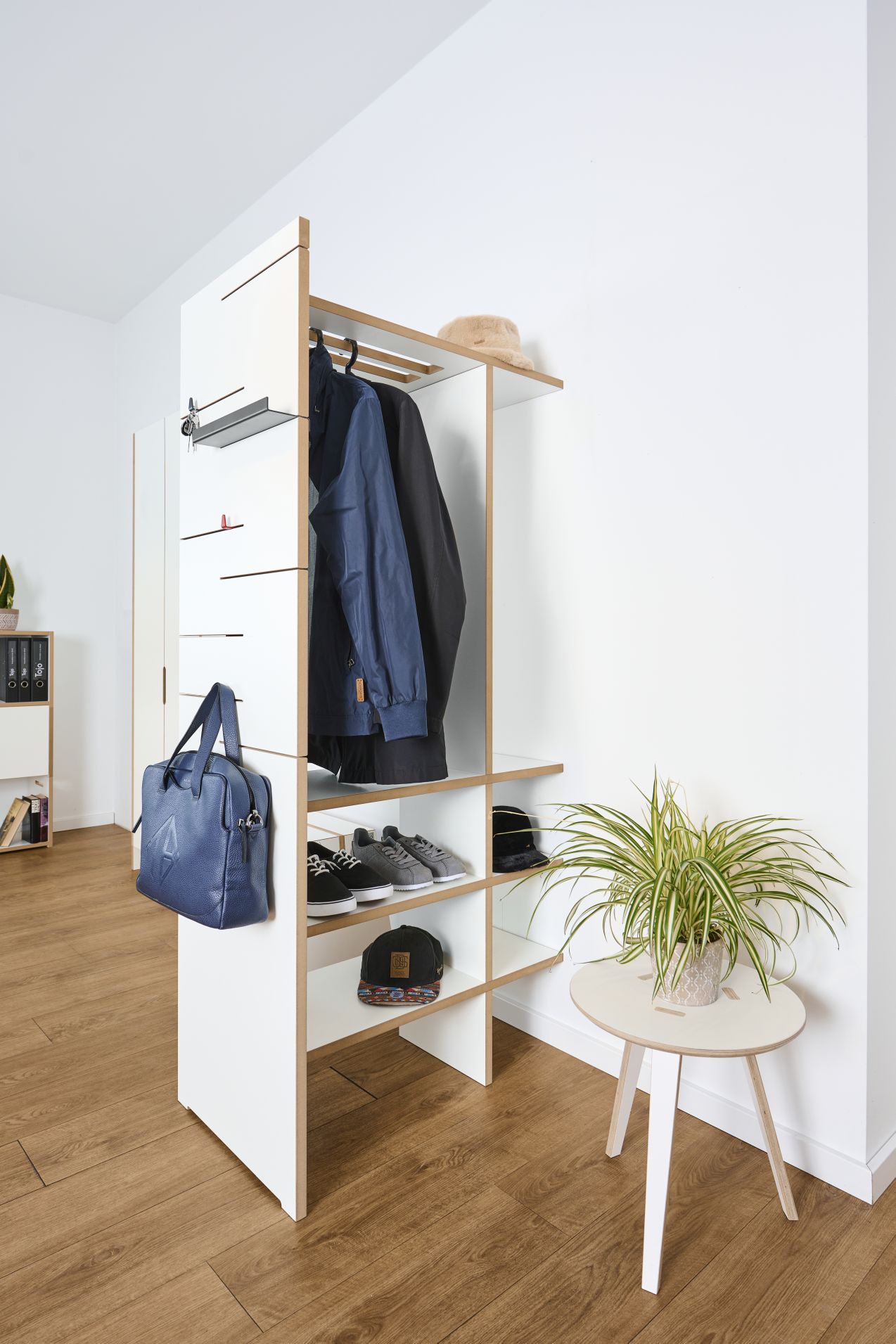 Moderner, offener Garderobenschrank in Weiß mit Kleidung, Schuhen und Accessoires für den Eingangsbereich.
