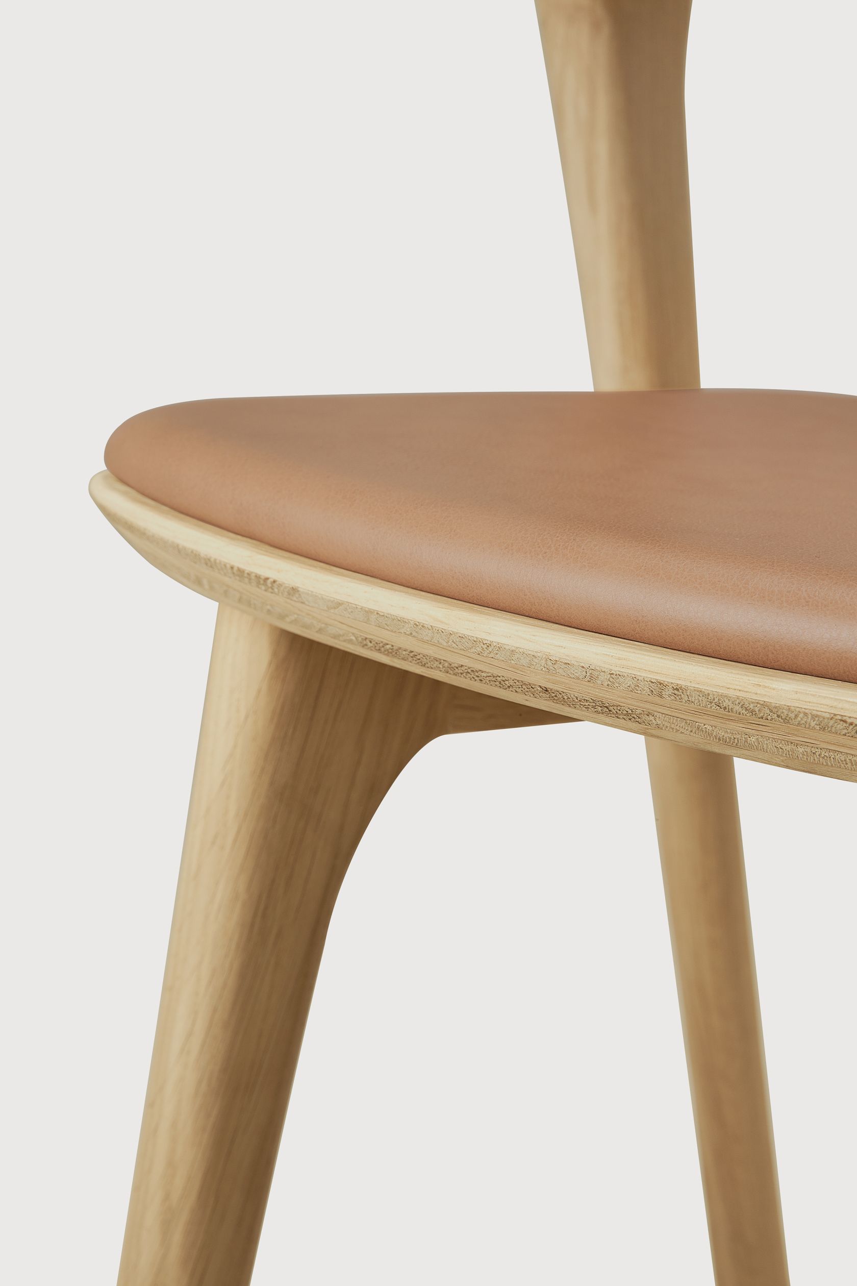 Detailaufnahme des Bok Stuhls von Ethnicraft: Lackierte Eiche mit Sienna Lederbezug, modernes Möbeldesign.