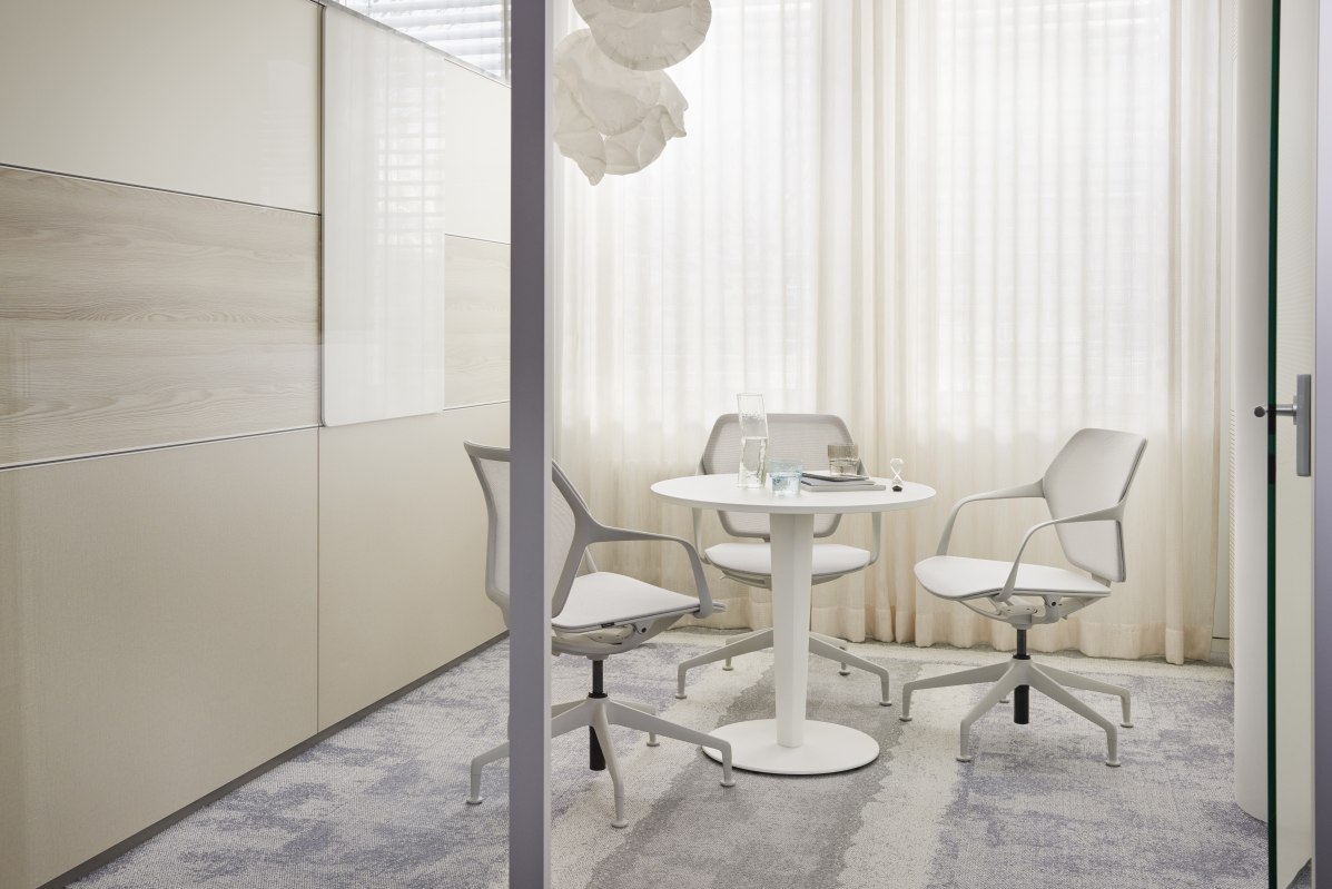 Ray Work Drehstühle von Brunner in einem modernen Büro mit weißem Tisch und Vorhängen.