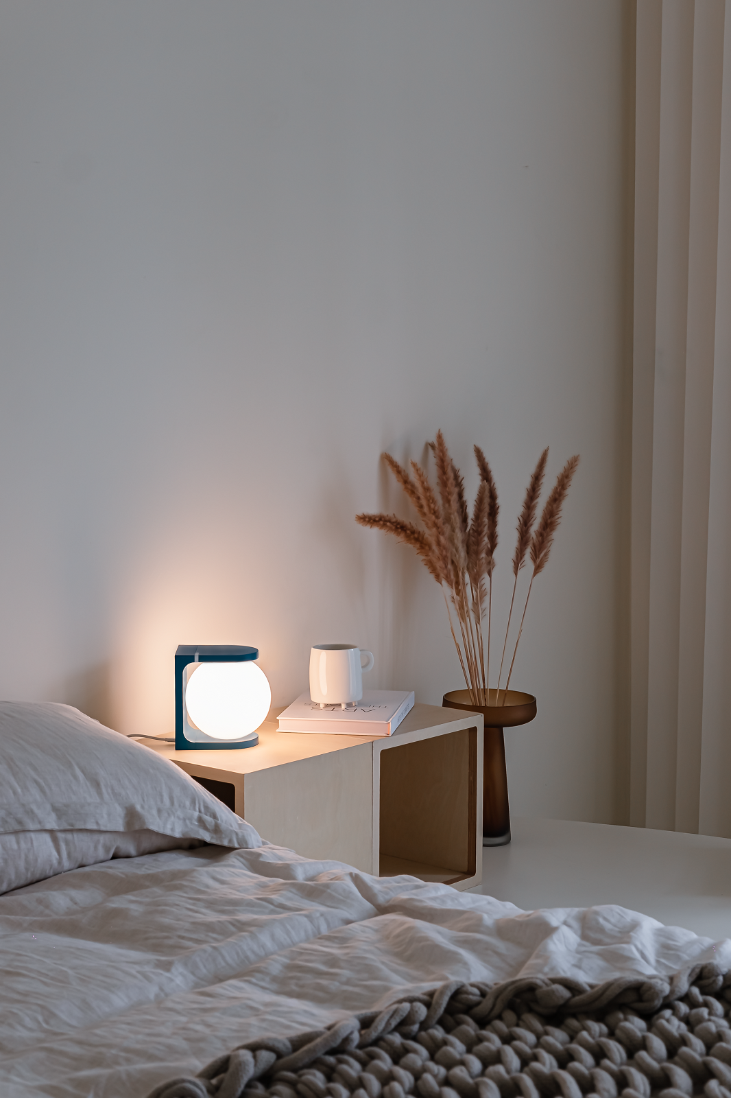 Plat Reading Lamp Tischleuchte von house of home auf Nachttisch neben Bett mit Dekoration.