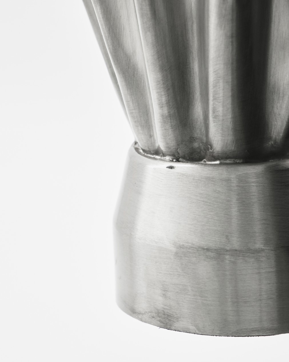 Detailaufnahme der House Doctor Vase HDFlood mit schmaler Form und gebürstetem Silber-Finish, moderne Tischdeko.