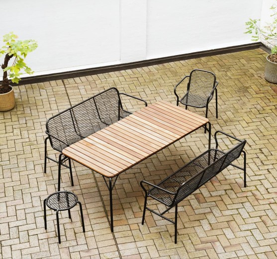 Normann Copenhagen Vig Stool, Teil einer Outdoor-Sitzgruppe mit Tisch und Bänken auf Terrasse.