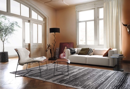 Cuoio Lounge Sessel von Walter Knoll mit Hocker und weißem Fell in modernem Wohnzimmer.