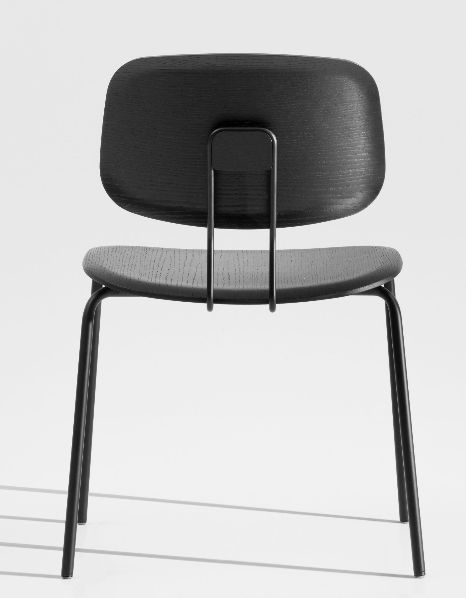 Rückansicht des Okito Ply Dining Chair Stuhls mit schwarzem Holz und Metallgestell.