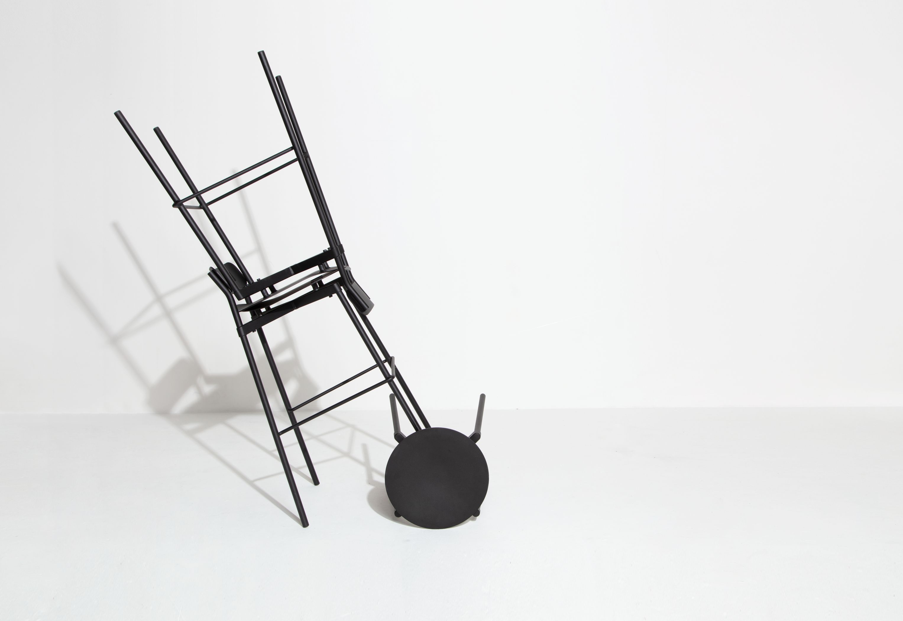 Gestapelte, schwarze Barhocker mit minimalistischem Design vor weißem Hintergrund. Moderne Hocker für Küche und Bar.