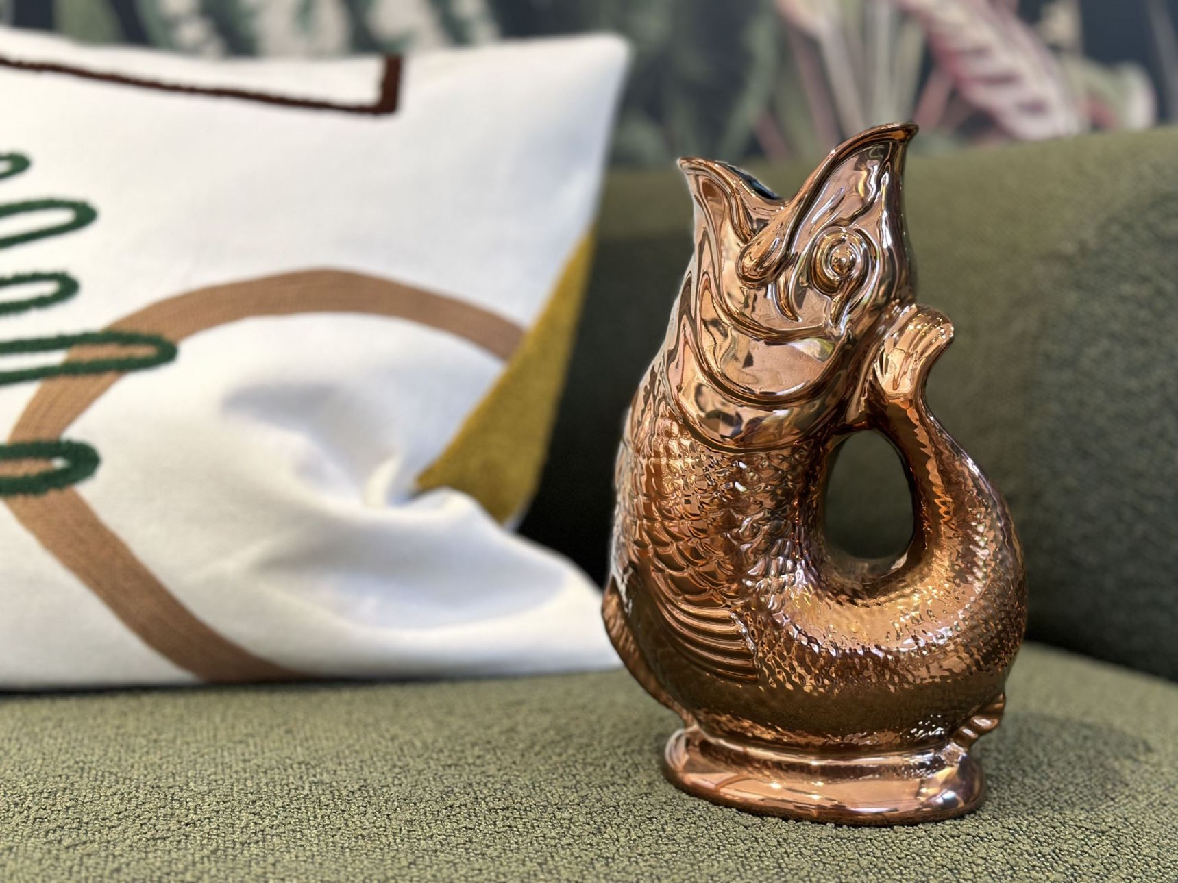 Nahaufnahme einer glänzenden, kupferfarbenen Fisch-Karaffe als dekoratives Wohnaccessoire für Tisch oder Regal.
