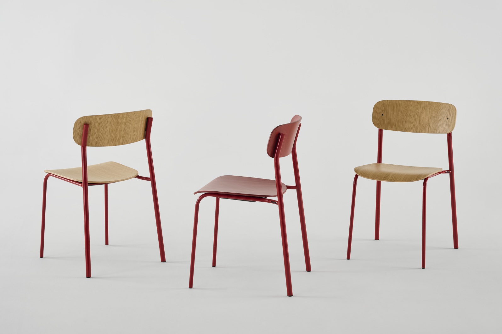 Drei S 243 Stahlrohr Stühle von Thonet, einer olivgrün, zwei in Naturholz mit rotem Gestell.