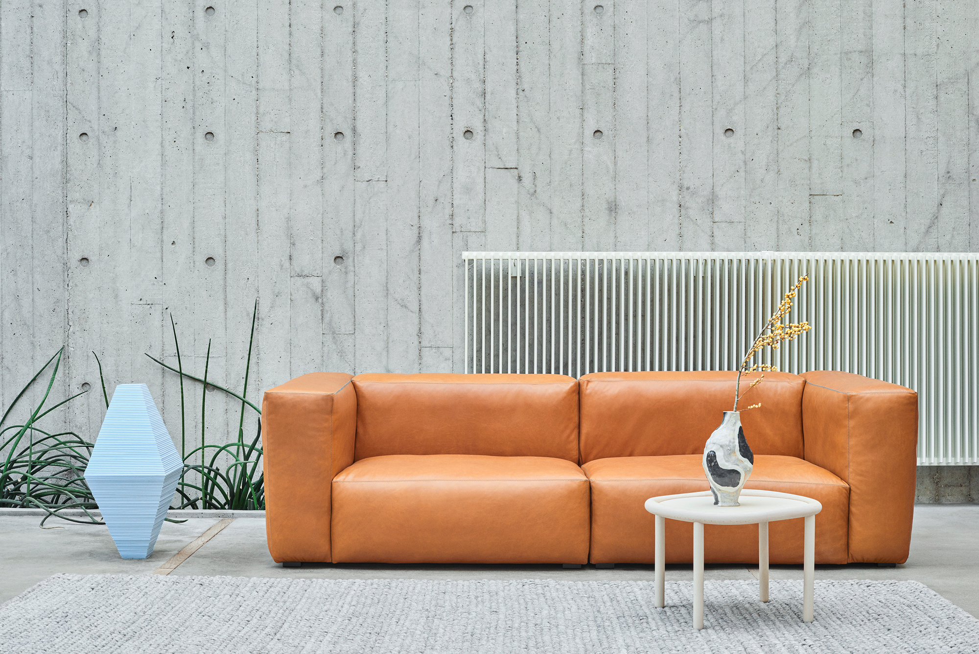 Hay Peas Teppich 140x80 cm in Grau vor einer modernen Wohnzimmer-Szene.