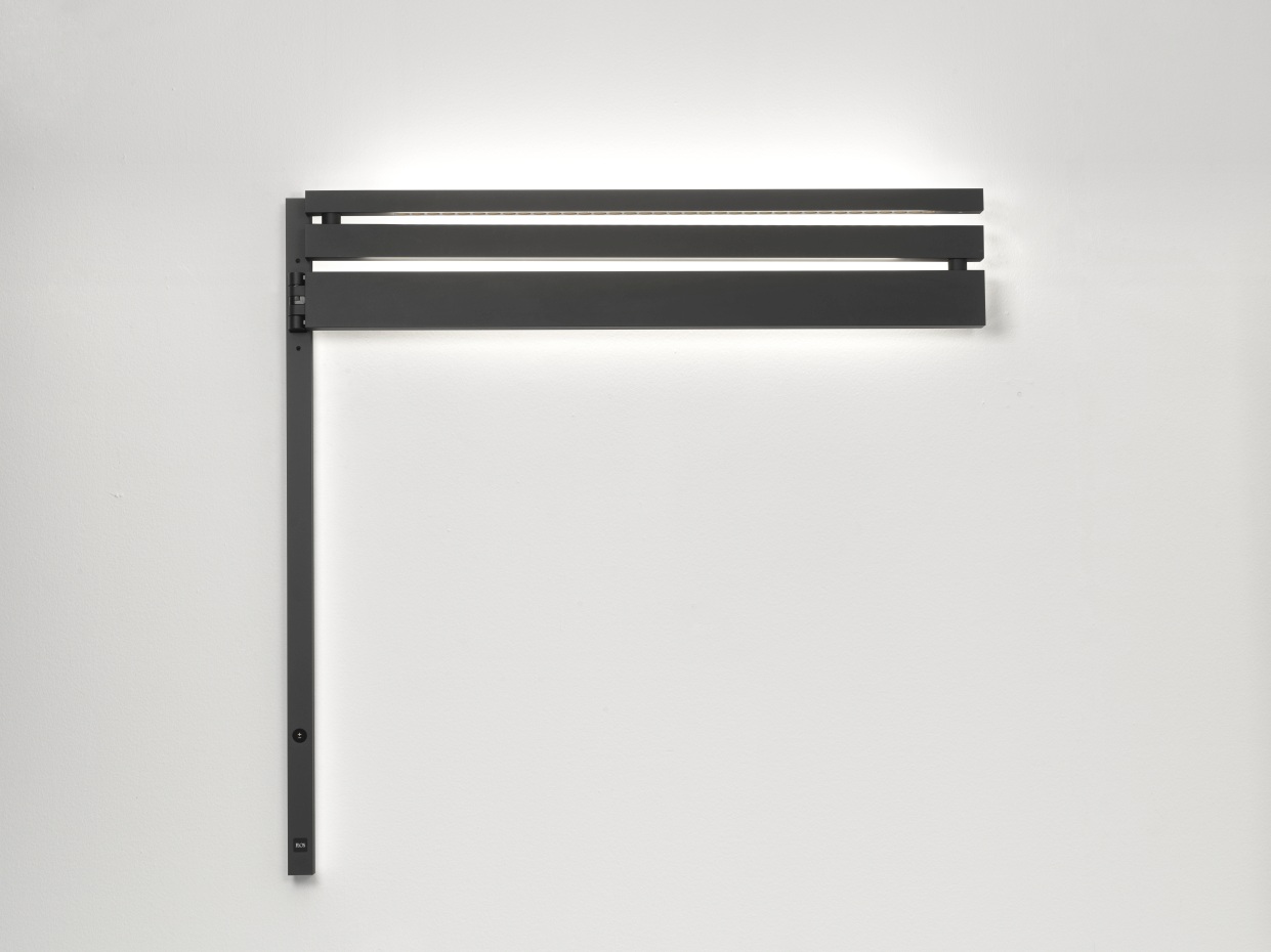 Schwarze Flos Black Flag Wandleuchte mit horizontalen Lamellen und integrierter LED-Beleuchtung an weißer Wand.