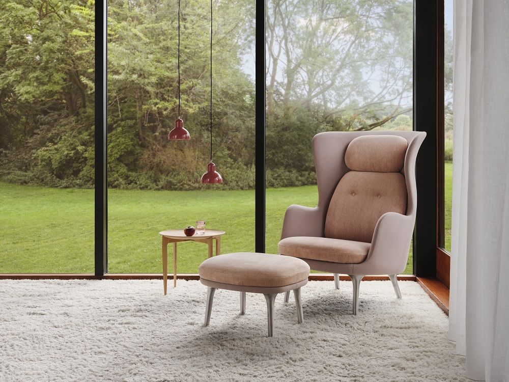 JH12 Fußhocker für Ro Sessel von Fritz Hansen in Beige vor Fenster mit Gartenblick.