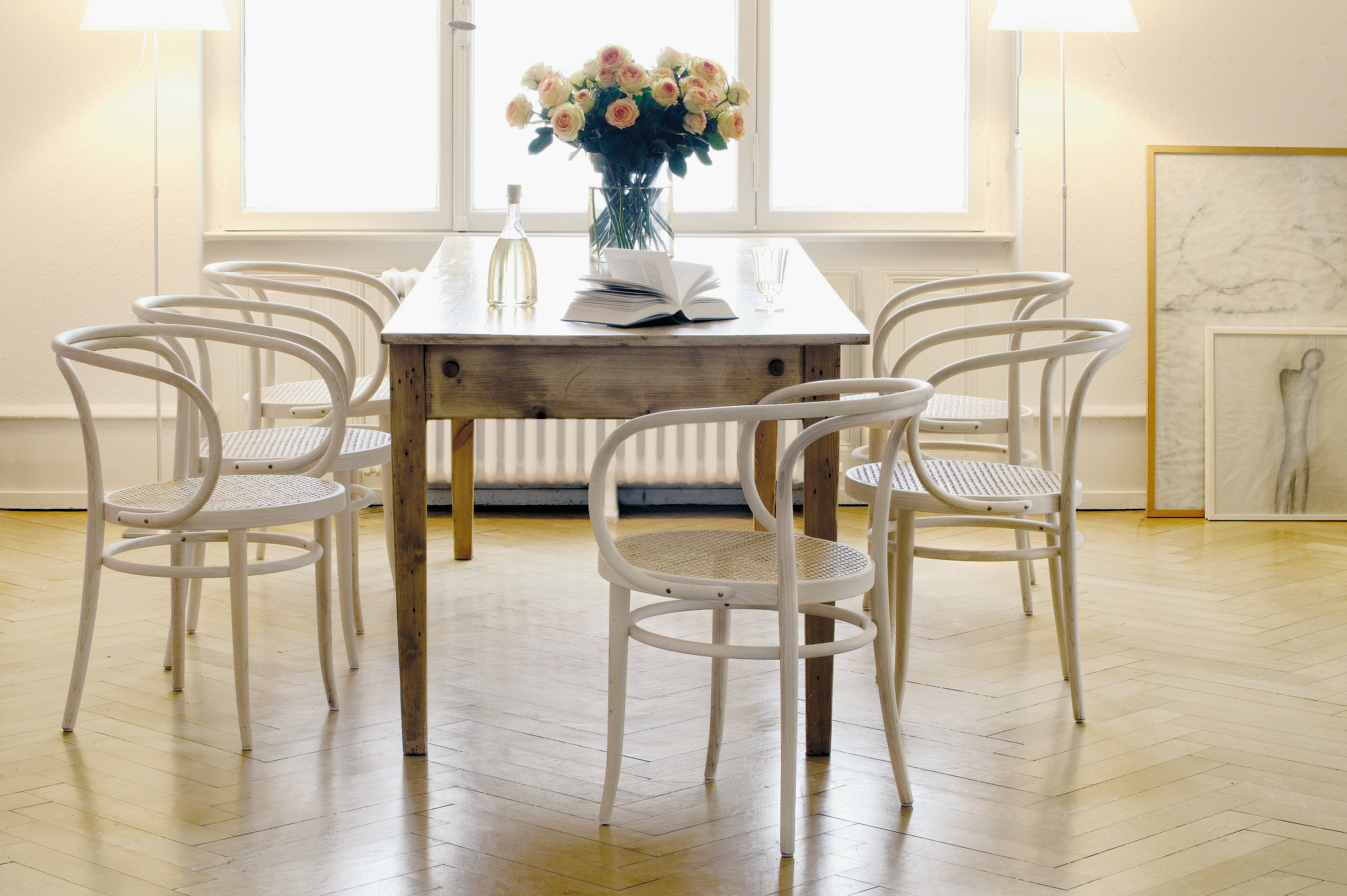 Esszimmer mit Holztisch und sechs weißen 209 Bugholz Stühlen von Thonet mit Wiener Geflecht.