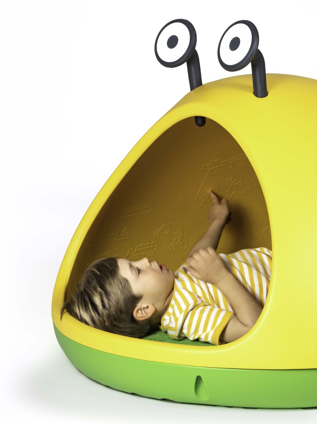 Junge liegt entspannt in der gelb-grünen Nido Höhle, einer Kindersitzgelegenheit mit fantasievollem Design.