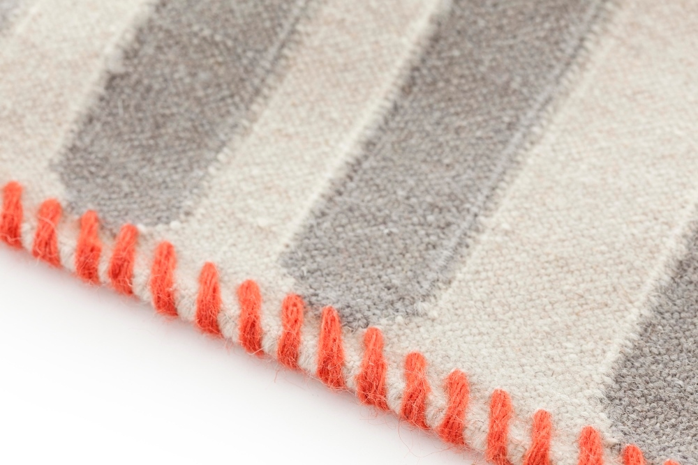 Detailaufnahme: Gestreifter Kilim Teppich mit orangefarbener Kante, ideal für Wohnzimmer und Schlafzimmer.