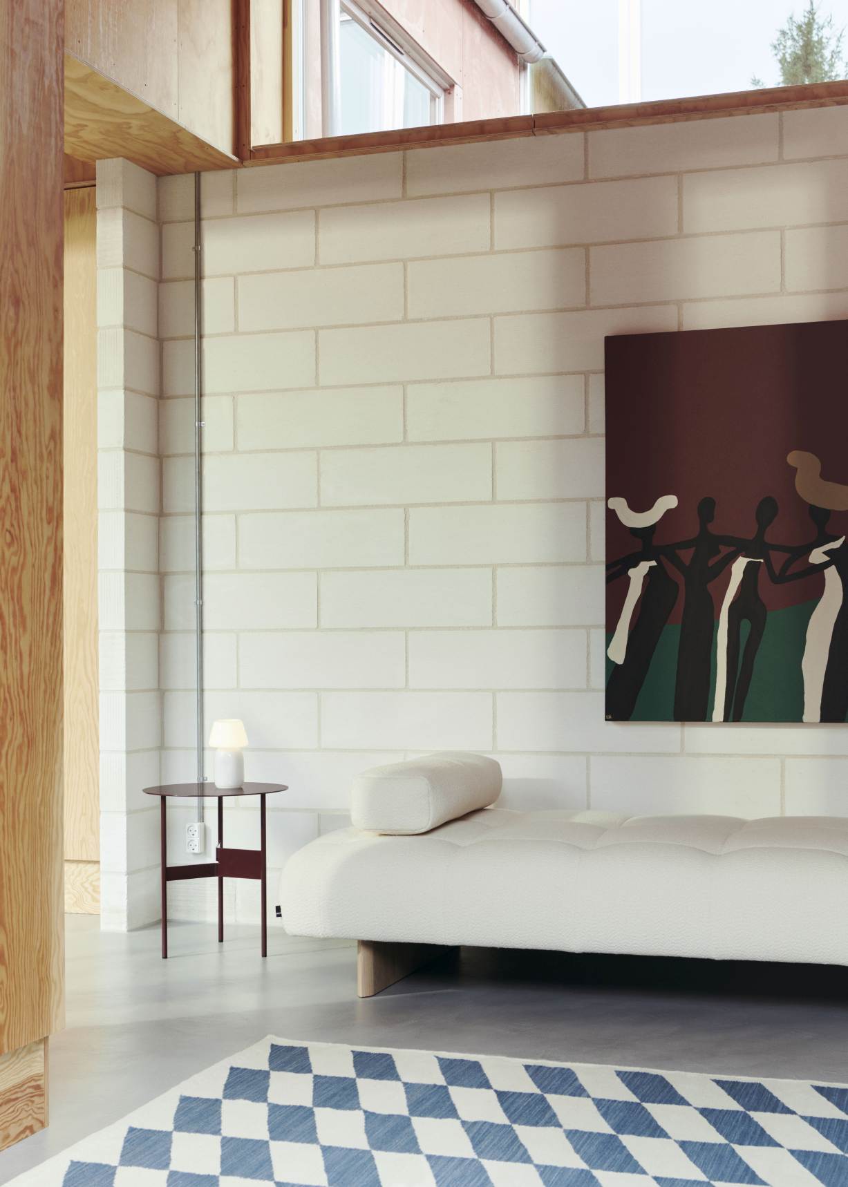 Nahaufnahme des Quilton Lift Daybed von Hay mit passendem Kissen in einem modernen Wohnraum.