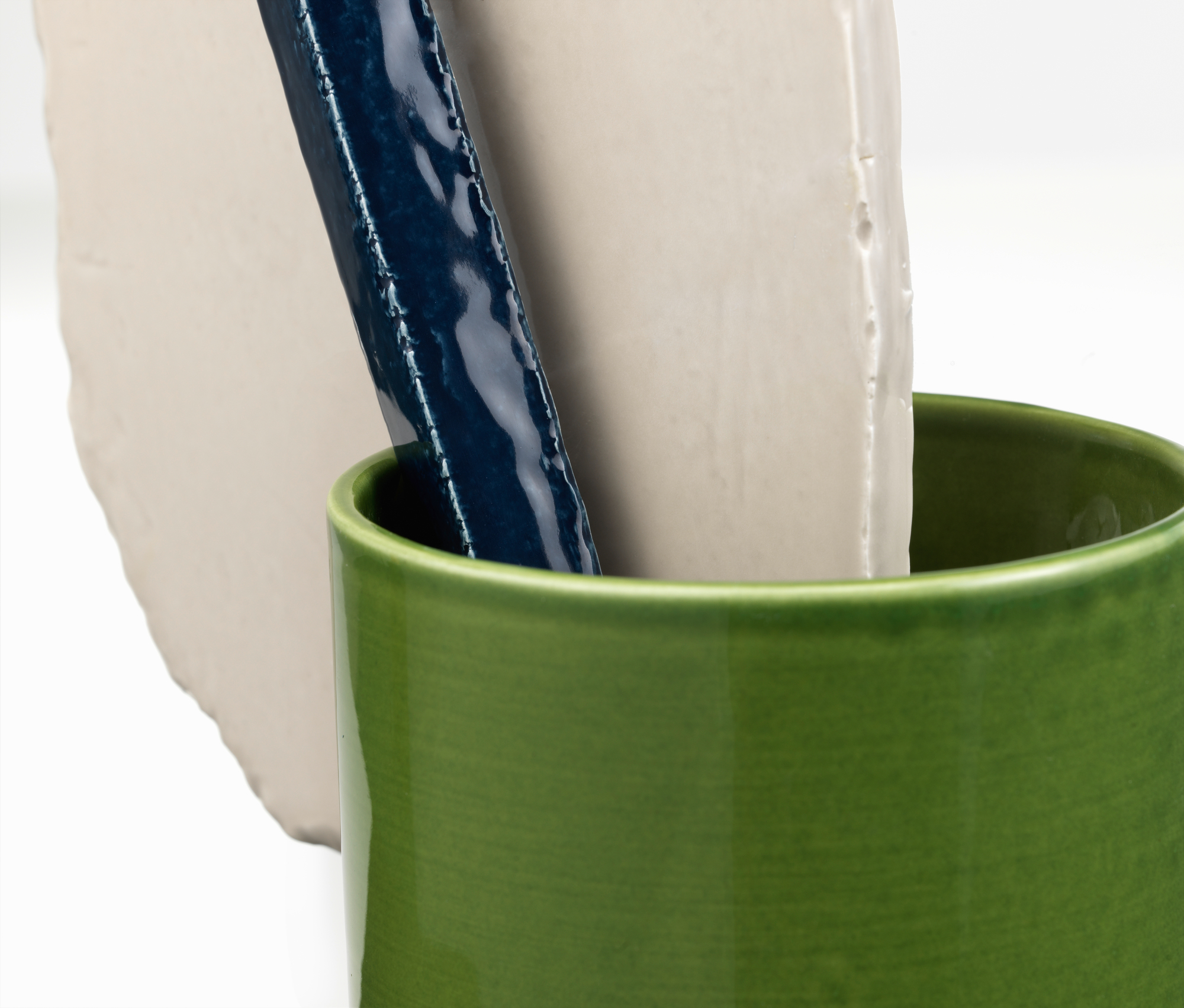 Vitra Découpage Vase: Grüne Keramikvase mit abstrakten, weißen und blauen Keramikformen als moderne Dekoration.