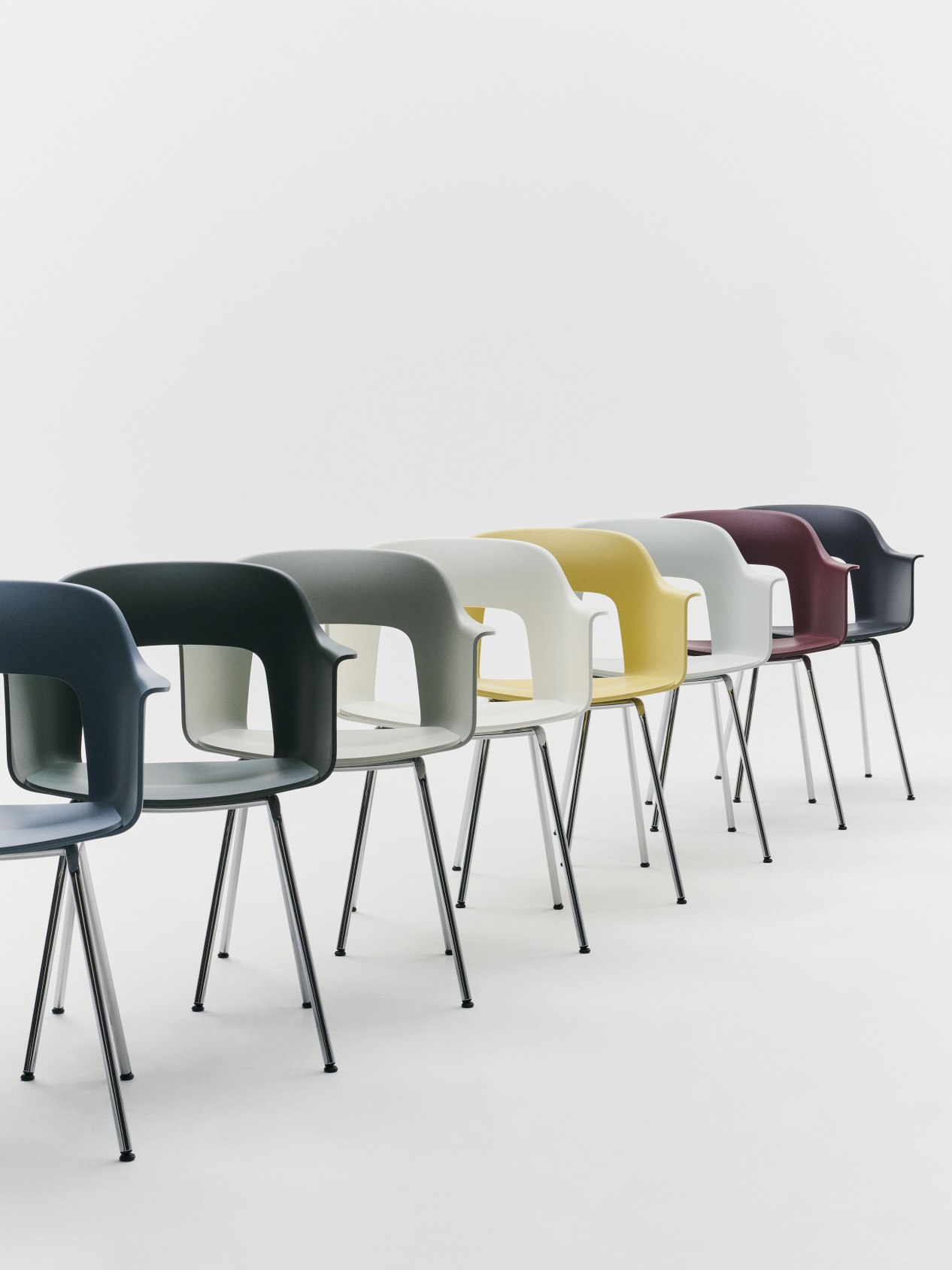 Reihe von Hay Layout Armchair 211 Stühlen in verschiedenen Farben mit Stahlbeinen auf weißem Hintergrund.