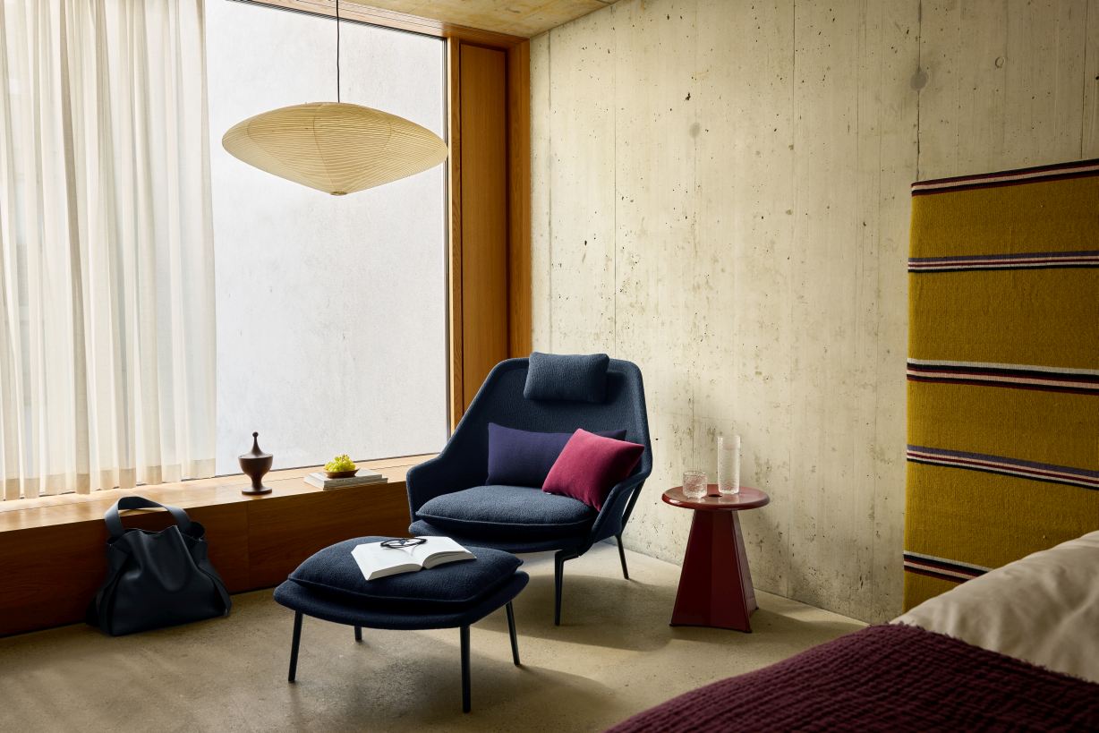 Vitra Slow Chair Sessel mit Hocker im modernen Wohnzimmer, Stoffbezug in dunklem Blau.
