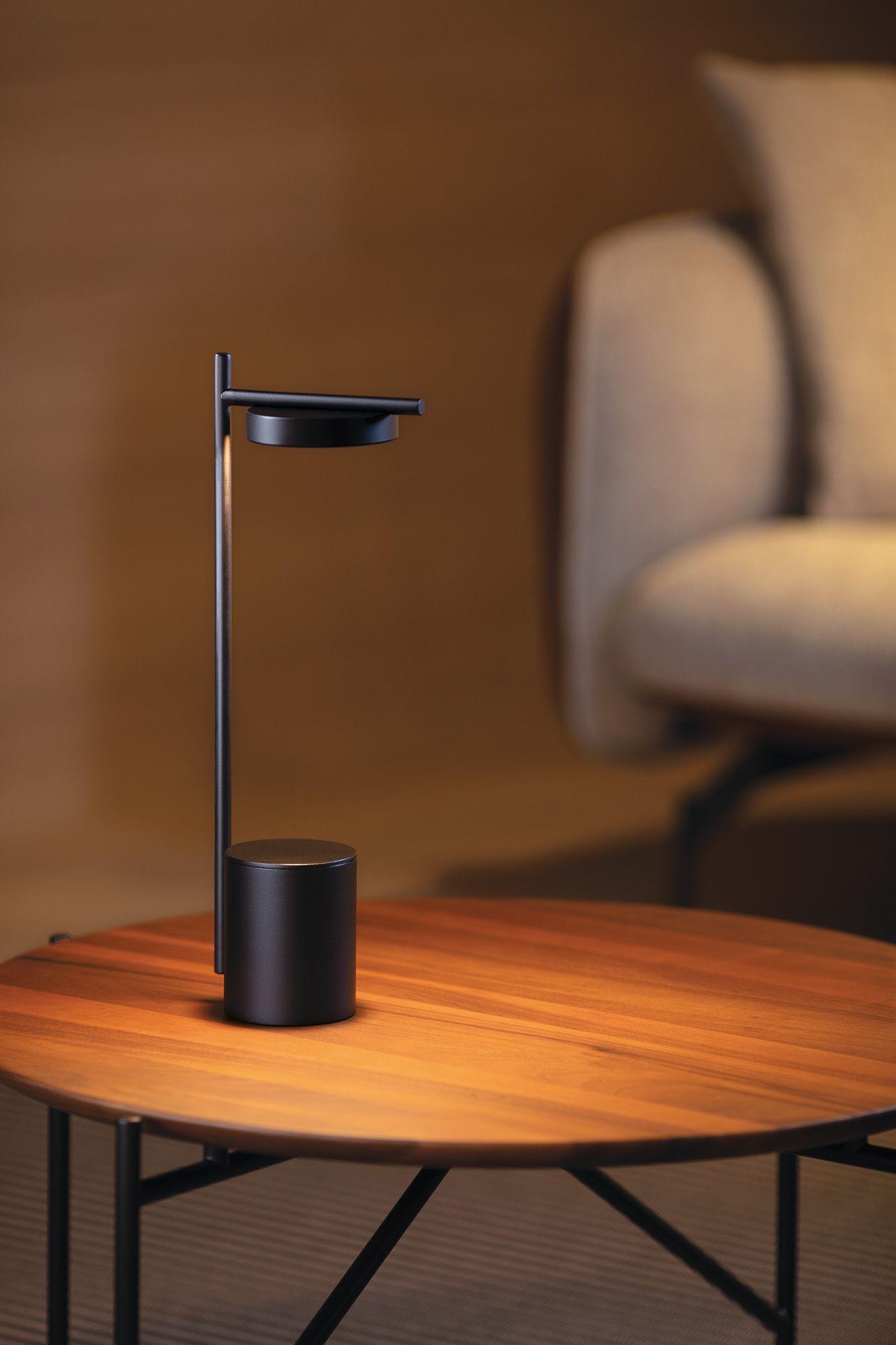 Igram Akku Tischleuchte von Grupa, modernes Design, schwarze tragbare Lampe auf einem Holztisch.