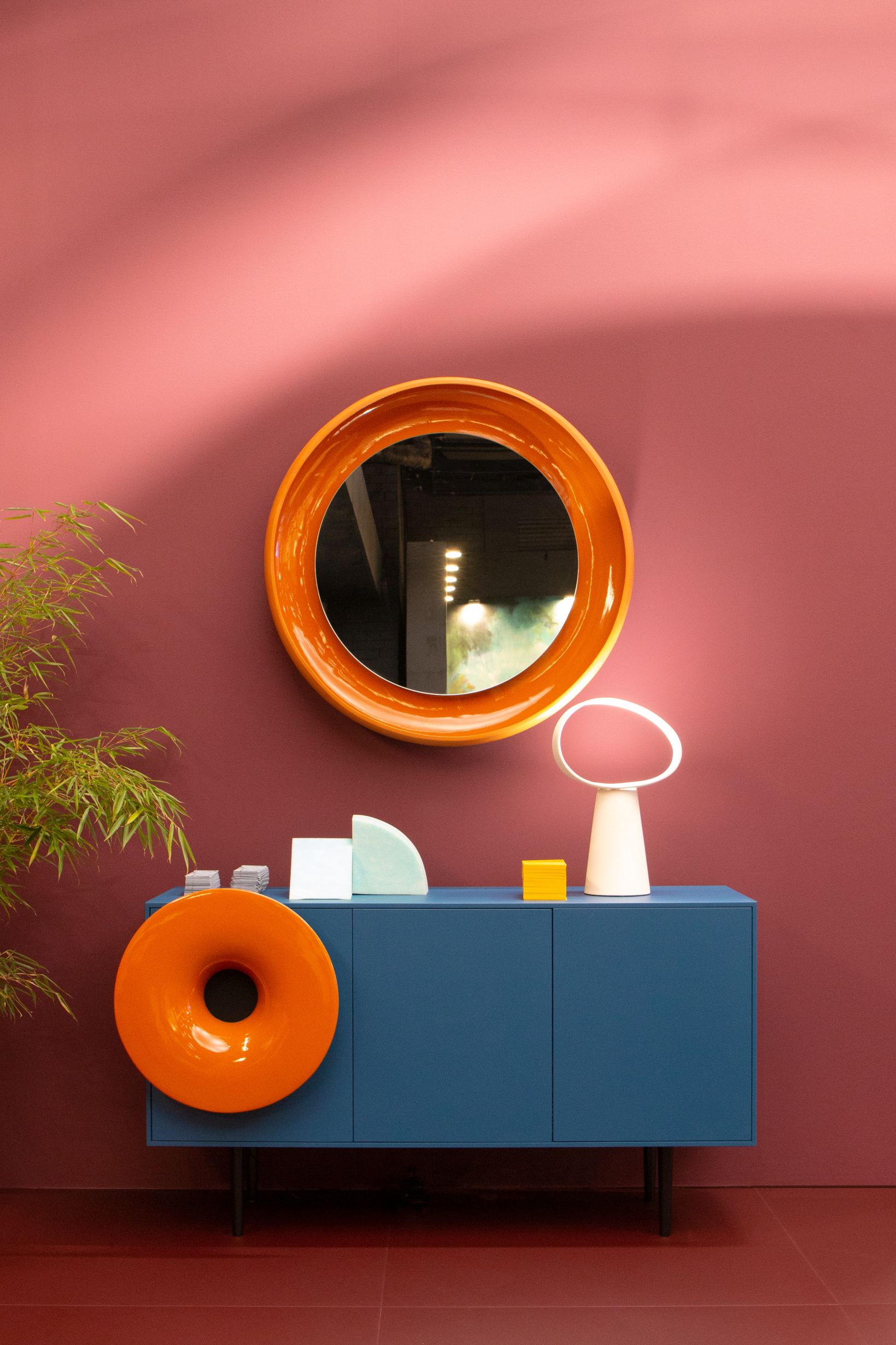 Blaue Miniforms Anrichte mit orangefarbenem Spiegel und Dekorationen. Modernes Sideboard für Wohnzimmer und Esszimmer.