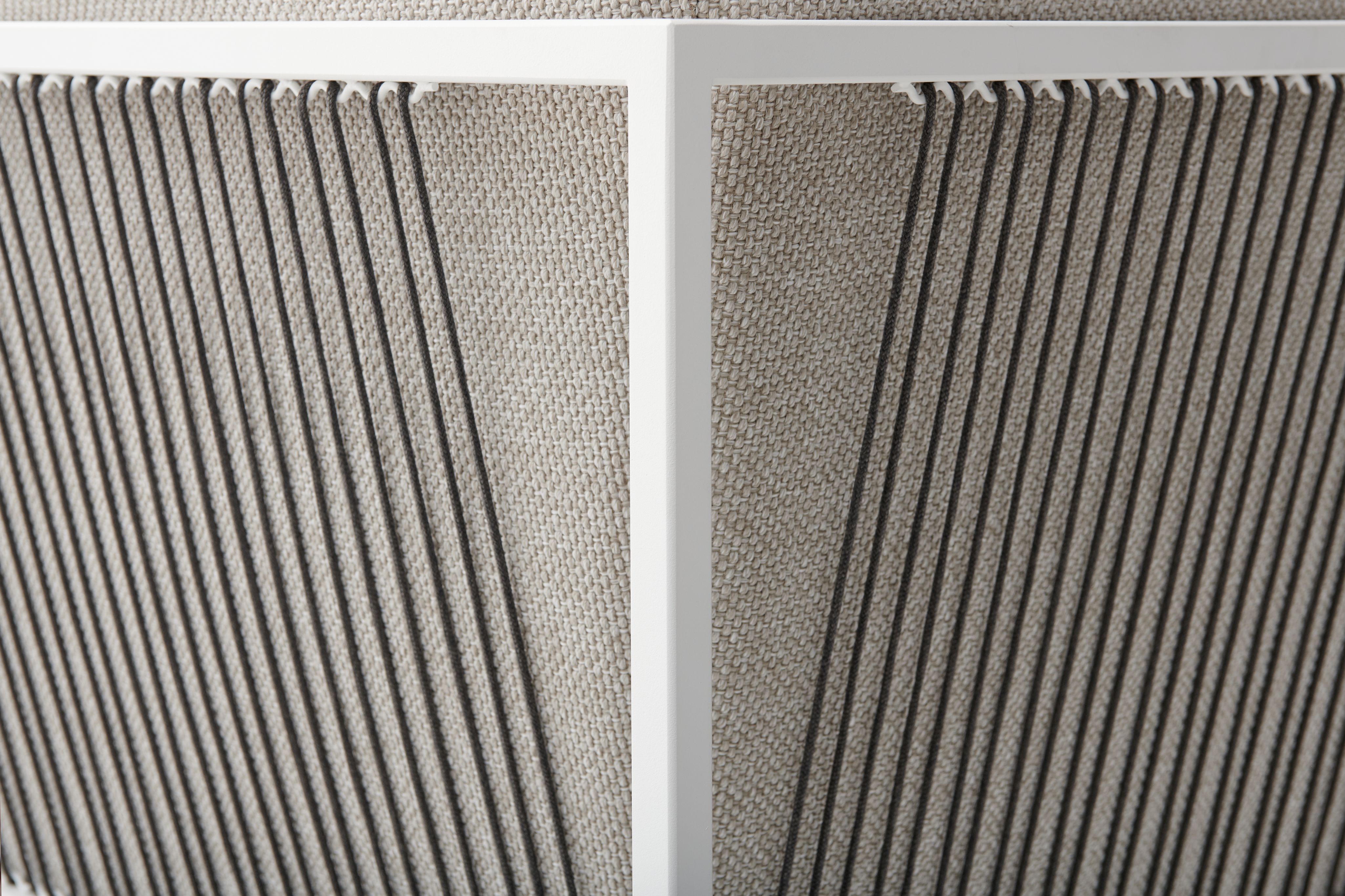 Detailaufnahme des Arpa Outdoor Sofas von MDF Italia: Weiße Rahmenstruktur mit grauem Textilbezug und vertikalen Schnüren.