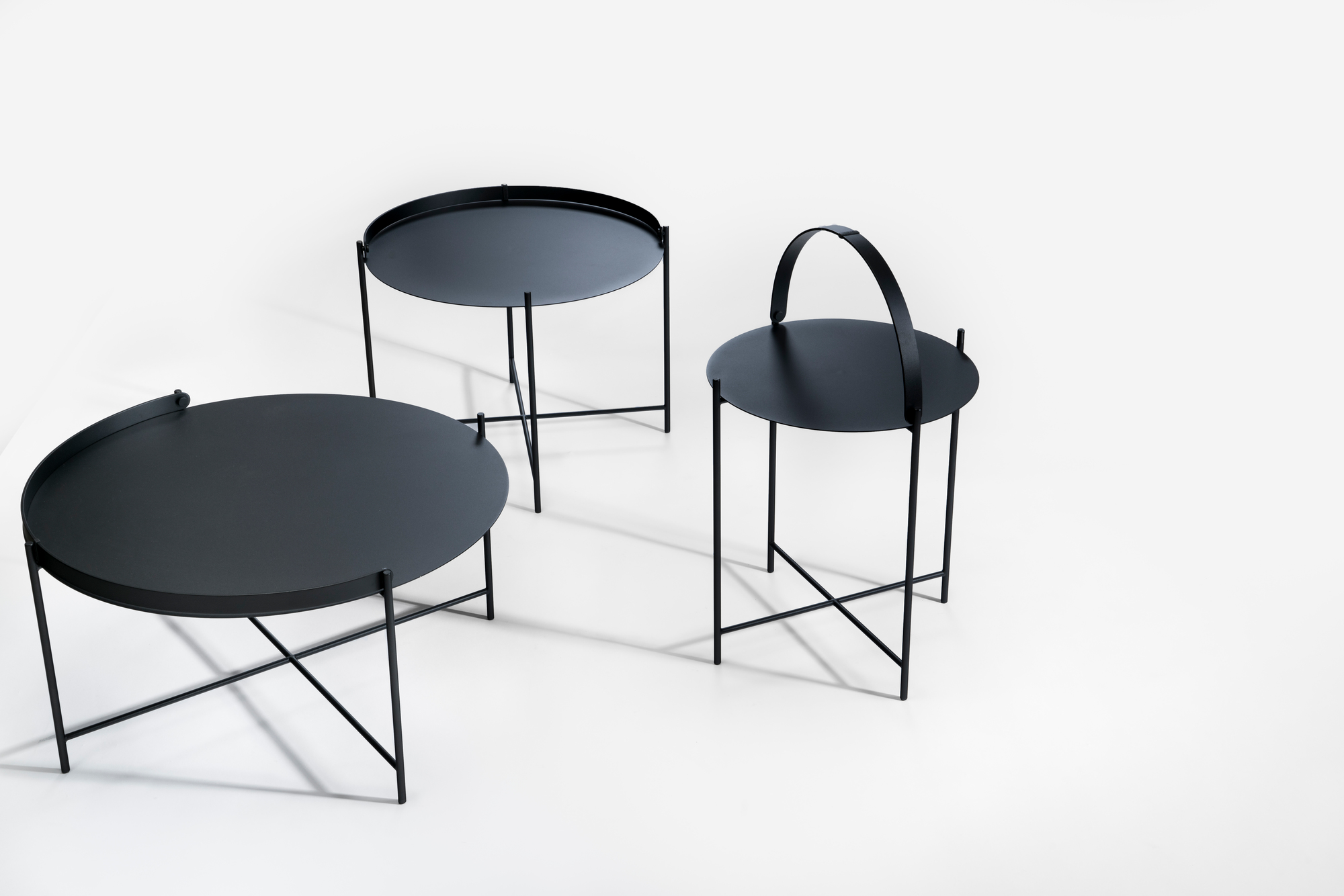 Drei schwarze Edge Tray Table Beistelltische von Houe auf weißem Hintergrund, verschiedene Höhen und Designs.