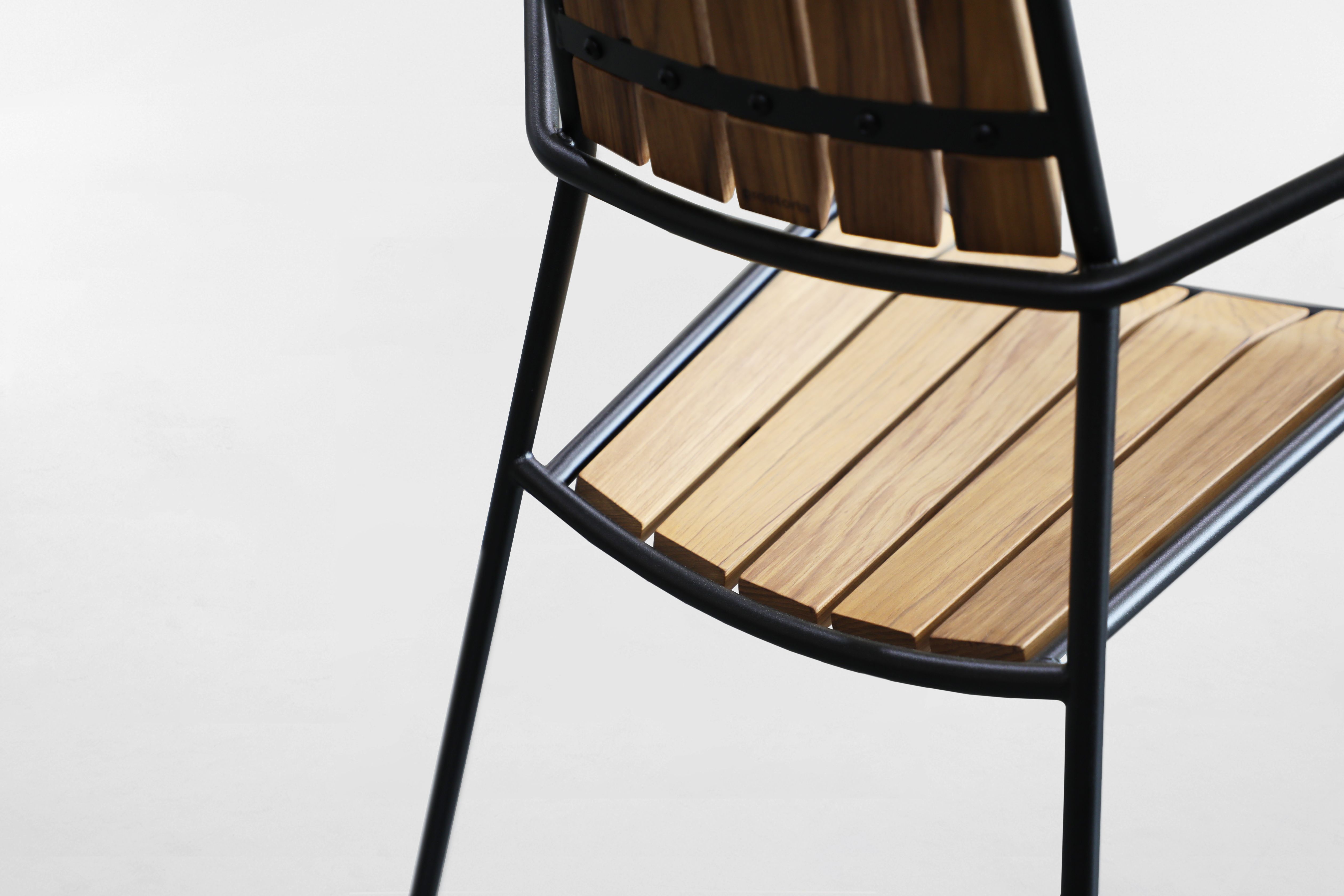 Detailansicht des Osmo Outdoor Stuhls von Prostoria: Teakholz und schwarzes Metallgestell.