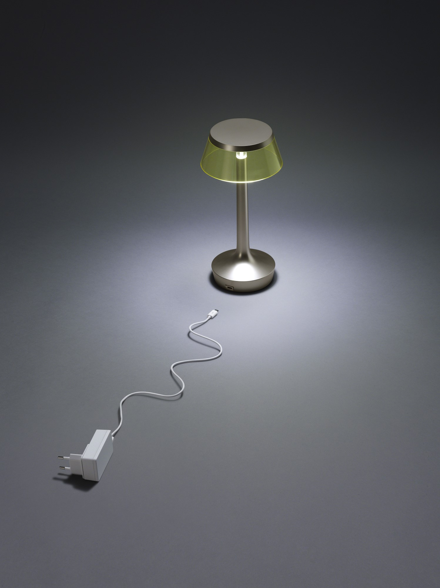Bon Jour Unplugged Tischleuchte Flos in Chrom mit gelbem Schirm und Ladekabel.