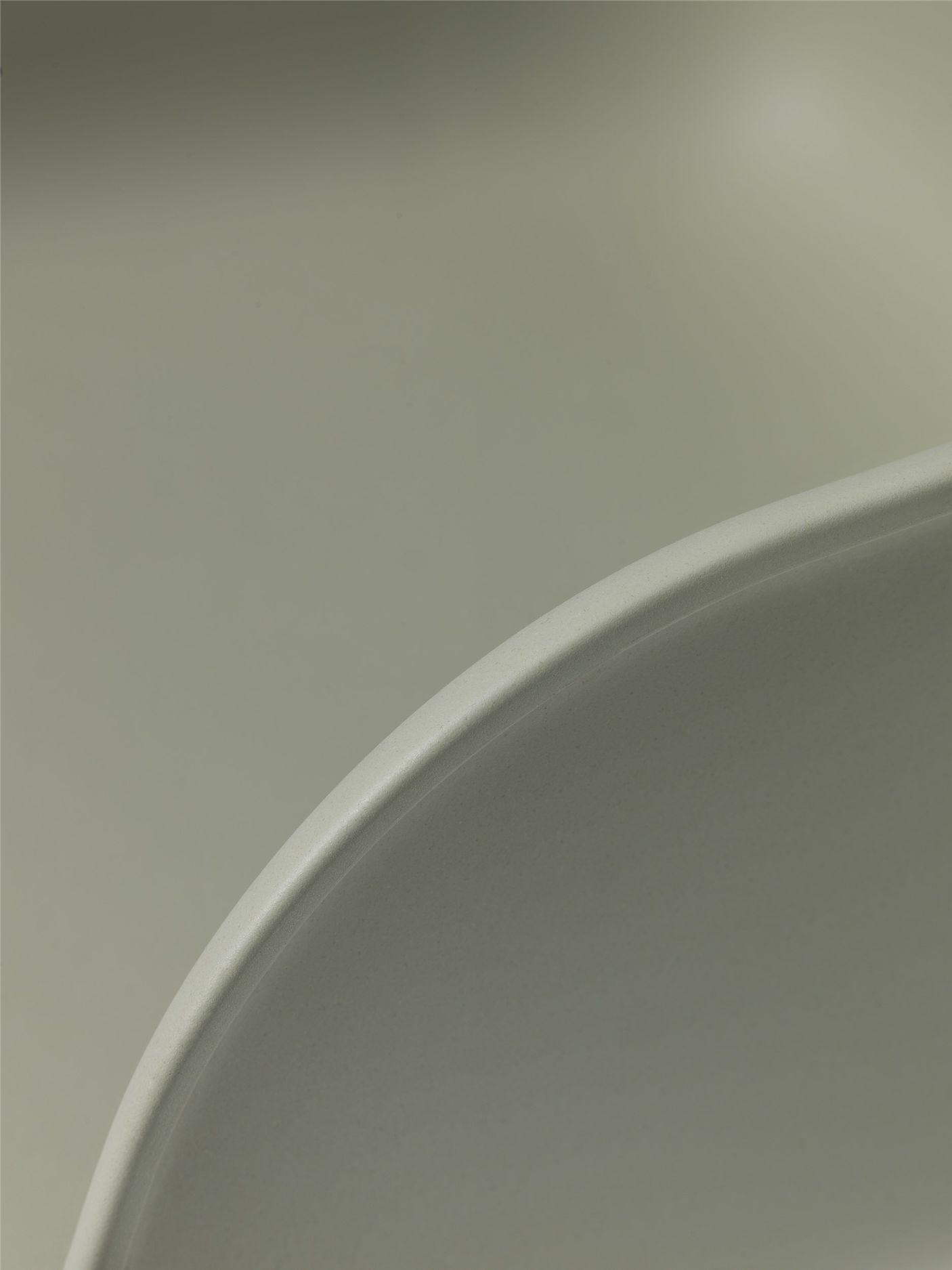 Detailaufnahme der Sitzschale vom Muuto Fiber Armchair in sanftem Grau, modernes Möbeldesign.