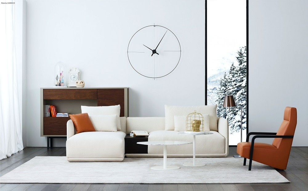 Minimalistische Bilbao N/ L Clock Wanduhr von nomon in Schwarz-Weiß an einer weißen Wand.
