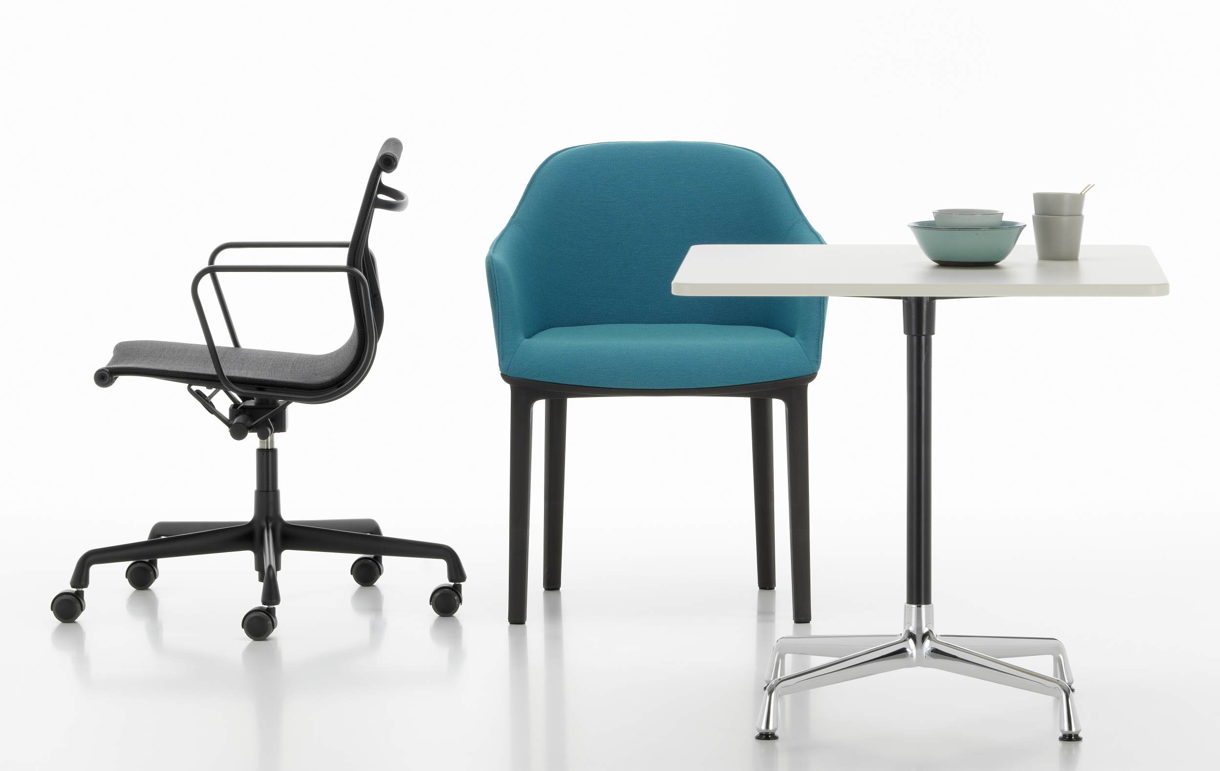 Eames Contract Table quadratisch von Vitra mit Bürostuhl und Sessel in einem modernen Büro.