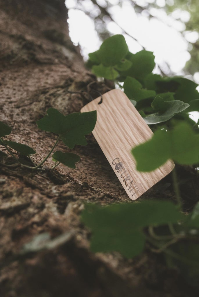 Holzschild von GoFurnit am Baumstamm mit Efeu, nachhaltige Möbel und Wohnaccessoires.