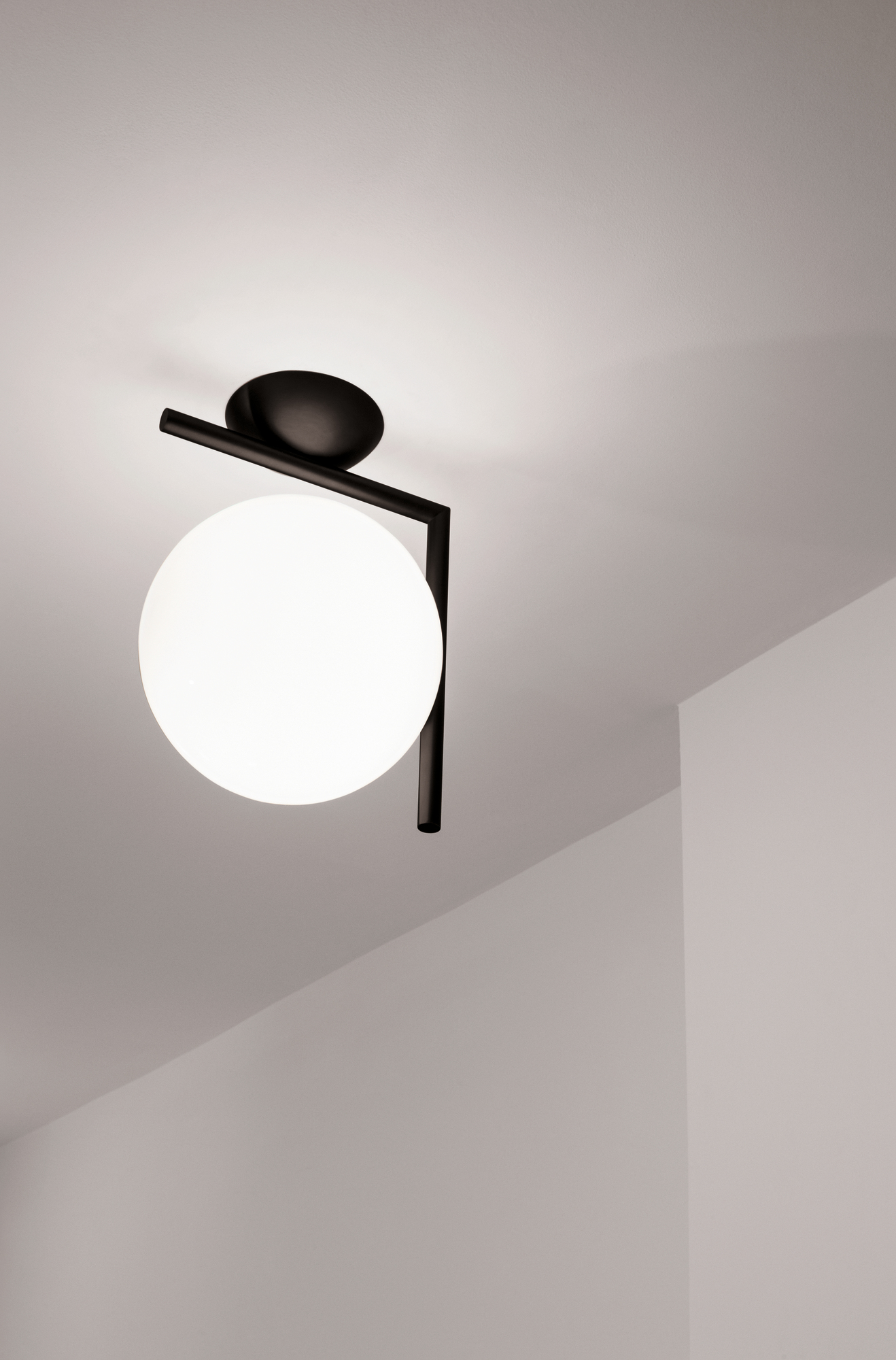 IC Lights Wandleuchte von Flos: Moderne Deckenleuchte mit schwarzem Gestell und weißem Opalglas.