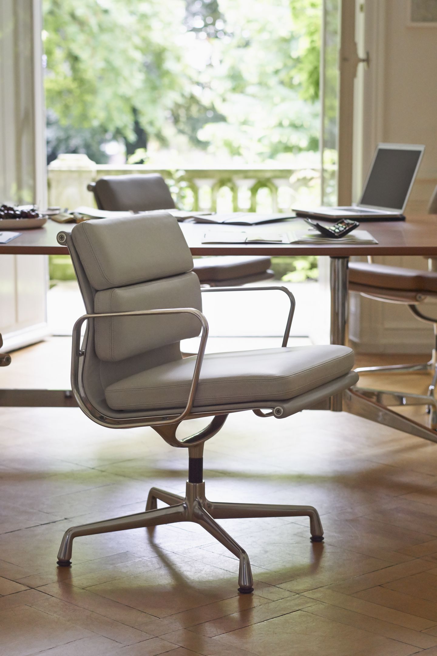 Nahaufnahme eines hellgrauen Vitra Soft Pad Chair EA 207 Bürostuhls mit Aluminiumgestell in einem Büro.
