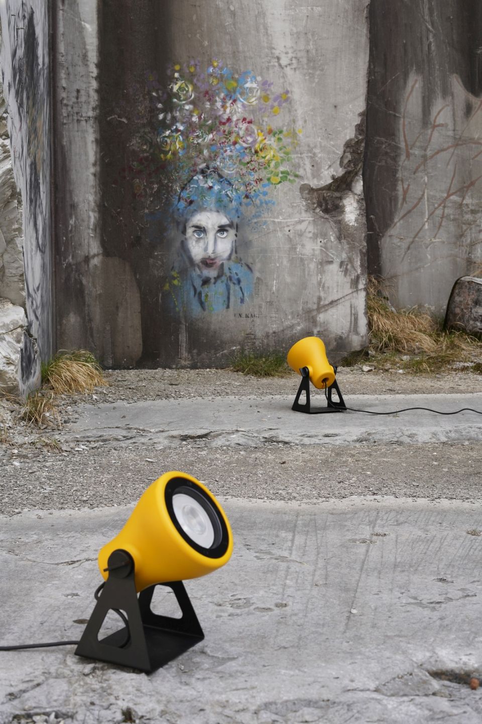 Gelbe Mini Frog Outdoor Leuchten von Martinelli Luce vor einer Betonwand mit Graffiti.