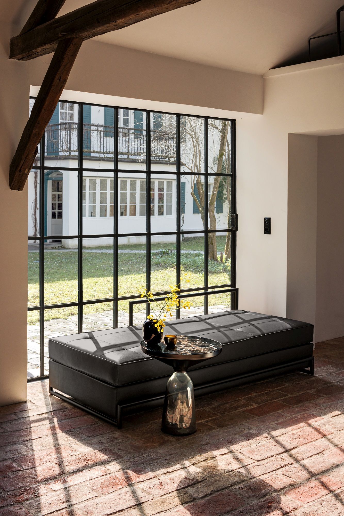 Classicon Day Bed Grand Liege in schwarzem Leder mit kleinem Beistelltisch und Blumenvase.