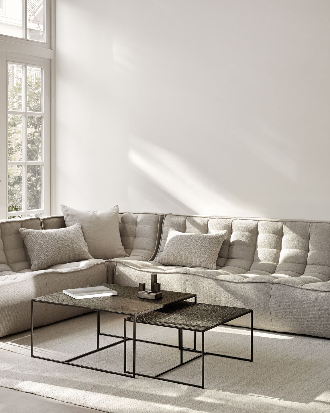 Pentagon Couchtisch 2er Set Whisky Ethnicraft vor einem hellen Sofa im Wohnzimmer.