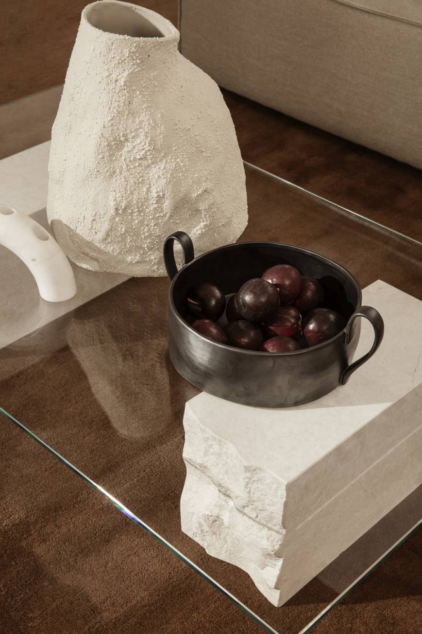 Nahaufnahme des Ferm Living Mineral Coffee Table Bianco Curia mit Pflaumen und dekorativer Keramikvase.