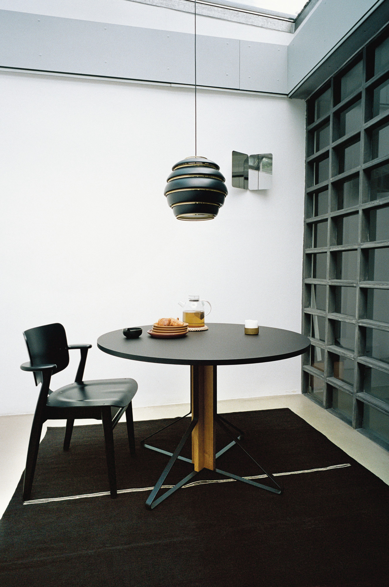 A331 Beehive Hängeleuchte in Schwarz über Esstisch mit Teegeschirr und schwarzem Stuhl.