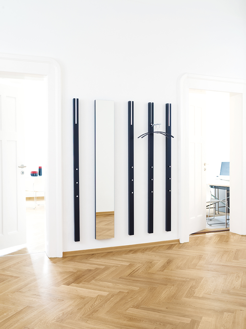 Line Garderobenelement von Schönbuch in indisch Gelb mit Spiegel und Kleiderbügel an der Wand.