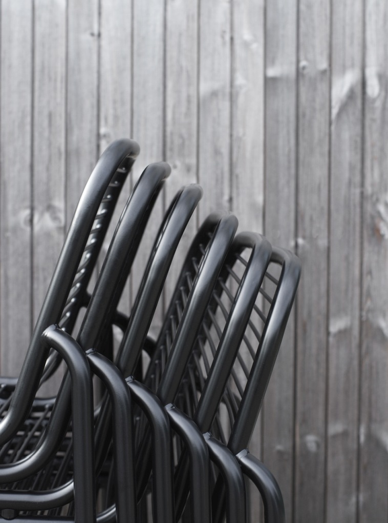 Detailaufnahme von gestapelten, schwarzen Vig Chair Stühlen von Normann Copenhagen für den Außenbereich.