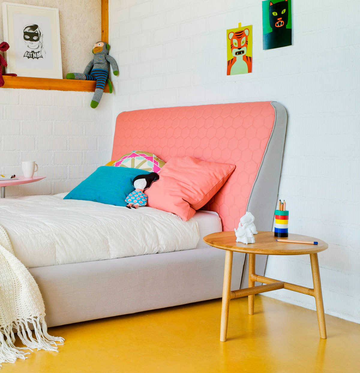 Nudo Beistelltisch Eiche Natur von Sancal im Kinderzimmer neben einem Bett mit farbenfrohen Kissen.