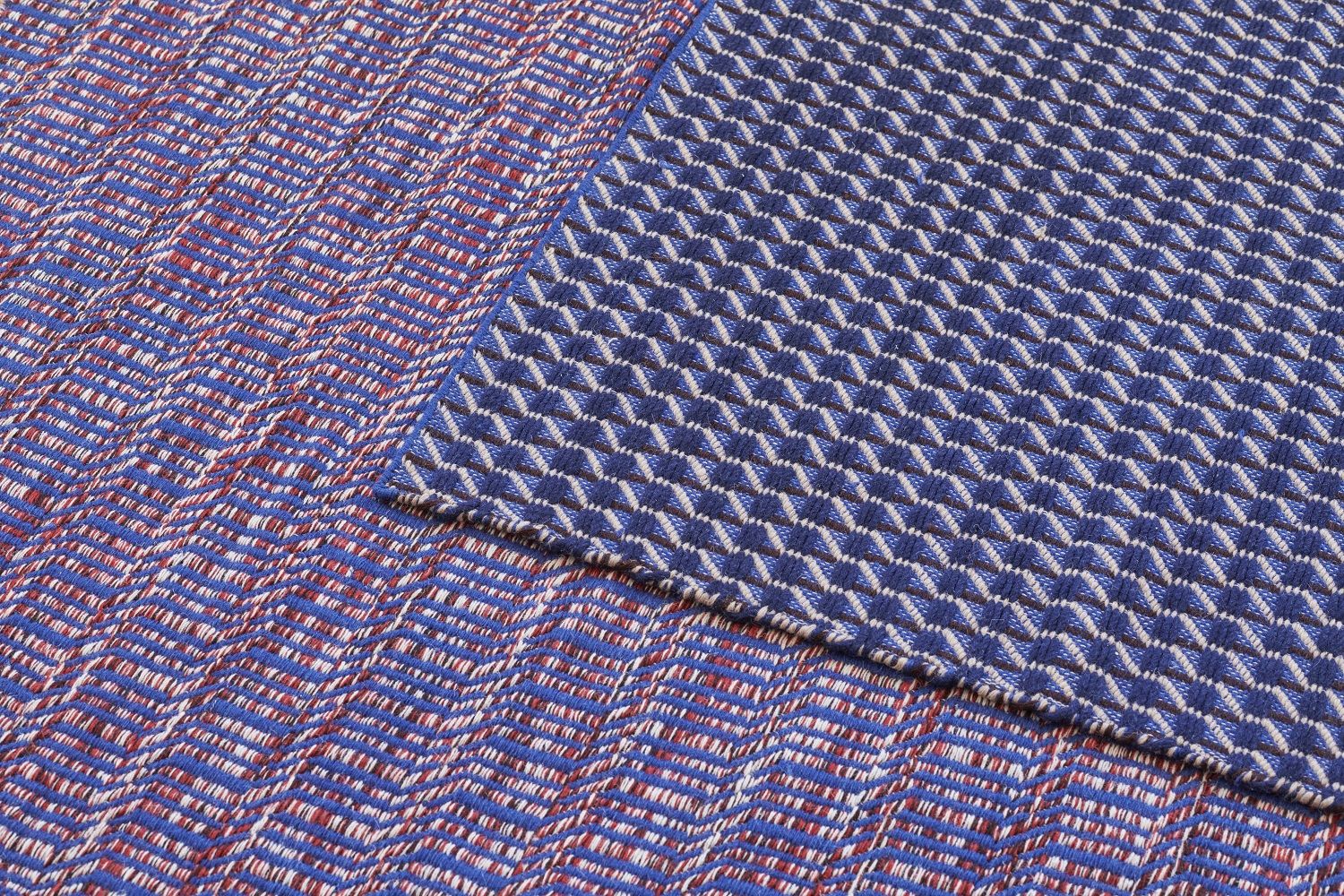 Detailaufnahme des Channel Rug Teppichs von Hay in Blau-Weiß mit geometrischen Mustern und Textur.