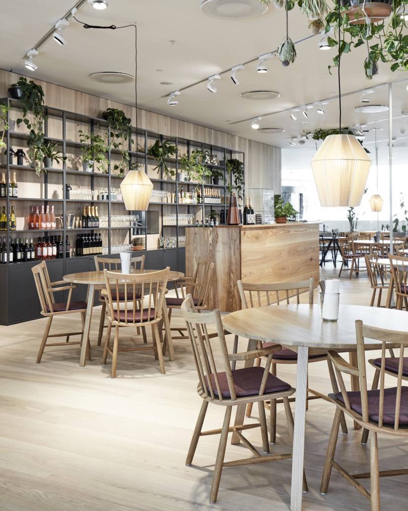 Innenansicht eines Restaurants mit mehreren runden Copenhague Table CPH 25 Tischen von Hay und passenden Holzstühlen.